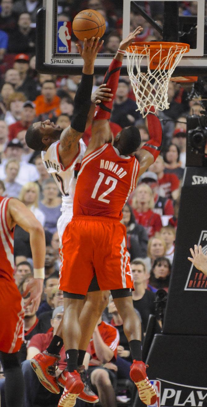 Houston Rockets' Dwight Howard (12) defends a shot by Portland Trail Blazers' LaMarcus Aldridge (12) during the first half of game four of an NBA basketball first-round playoff series game in Portland, Ore., Sunday March 30, 2014. (AP Photo/Greg Wahl-Stephens)