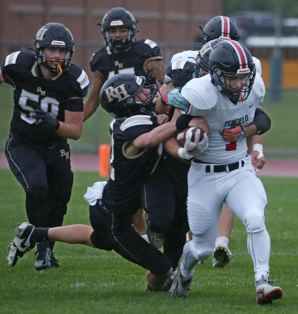 Penfield running back Nicholas Masters drags a pile of Rush-Henrietta defenders as he picks up a first down in the first quarter.