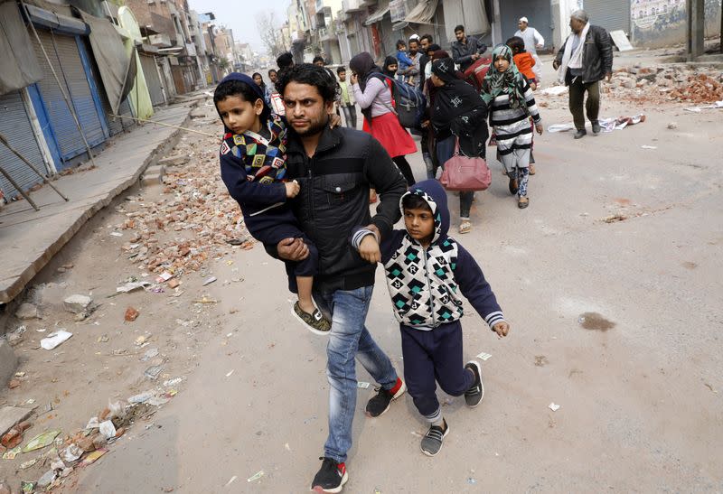 Muslims leave a Hindu dominated locality in a riot affected area after clashes erupted between people demonstrating for and against a new citizenship law in New Delhi