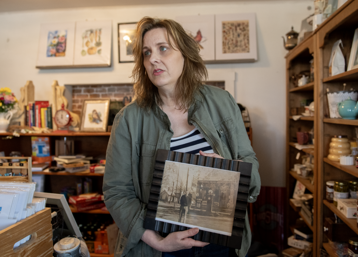 Beverly Scandlon, owner of Chatham General Store since 2020, with an old photograph of the store, in the Medina County store on Thursday, April 18.