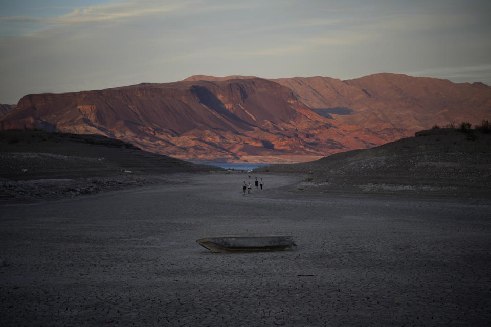 A formally sunken boat sits on cracked earth hundreds of feet from what is now the shoreline on Lake Mead at the Lake Mead National Recreation Area, Monday, May 9, 2022, near Boulder City, Nev. Lake Mead is receding and Sin City is awash with mob lore after a second set of human remains emerged within a week from the depths of the drought-stricken Colorado River reservoir just a short drive from the Las Vegas Strip. (AP Photo/John Locher)