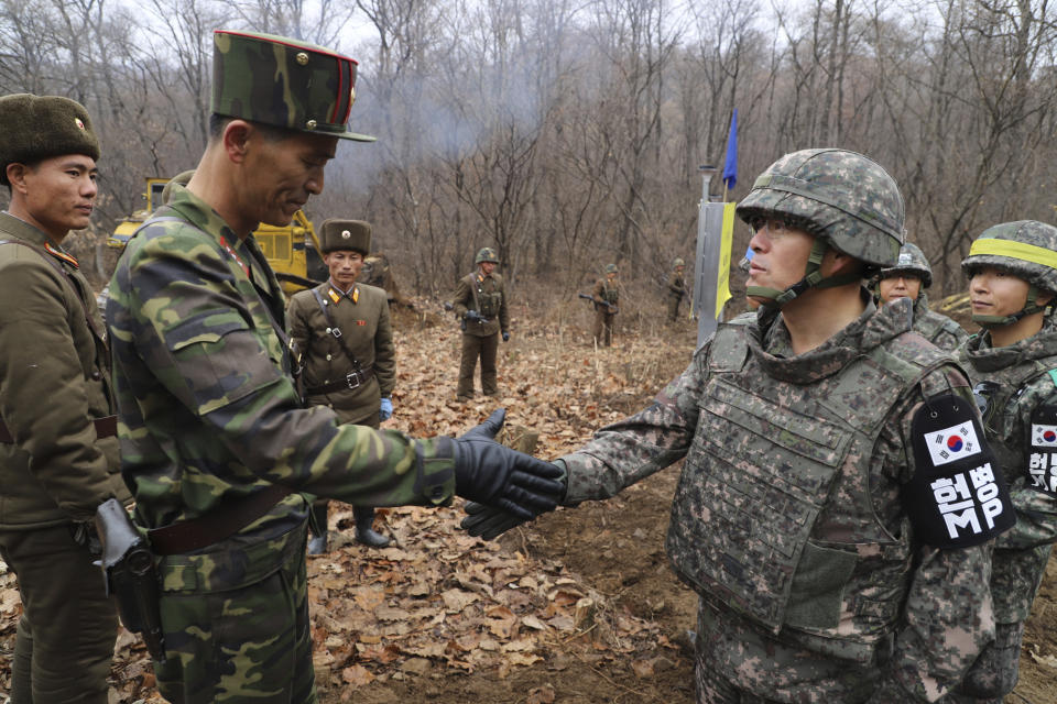 FILE - In this undated file photo provided by South Korea Defense Ministry, a South Korean soldier, right, and North Korean soldier shake hands as they meet to open a road connecting the two sides across the demilitarized zone in a project to excavate Korean War remains near the military demarcation line inside the Demilitarized Zone in Cheorwon, South Korea. With their second summit fast approaching, speculation is growing that U.S. President Donald Trump may try to persuade North Korean leader Kim Jong Un to commit to denuclearization by giving him something he wants more than almost anything else, an announcement of peace and an end to the Korean War.(South Korea Defense Ministry via AP, File)