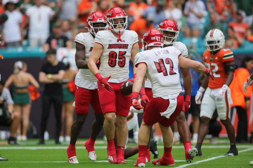 Louisville Cardinals tight end Nate Kurisky (85) celebrates with fellow tight end Josh Lifson (42) after catching the football against the Miami Hurricanes during the first quarter at Hard Rock Stadium.