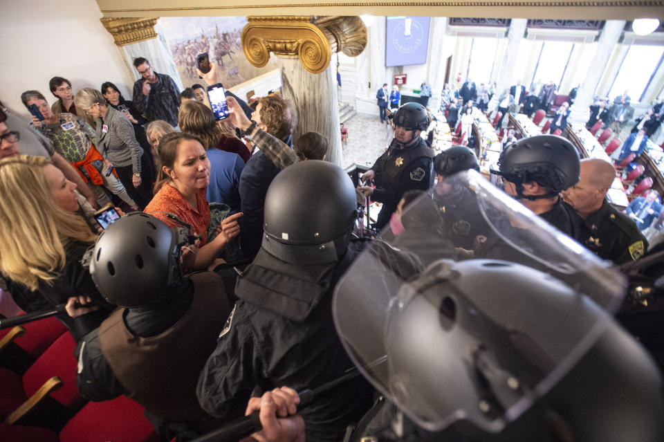 Law enforcement forcibly clear the Montana House of Representatives gallery during a protest after the Speaker of the House refused again to acknowledge Rep. Zooey Zephyr, D-Missoula, on Monday, April 24, 2023, in the State Capitol, in Helena, Mont. Republican legislative leaders in Montana persisted in forbidding the Democratic transgender lawmaker from participating in debate for a second week as her supporters brought the House session to a halt Monday, chanting "Let her speak!" from the gallery before they were escorted out. (Thom Bridge/Independent Record via AP)