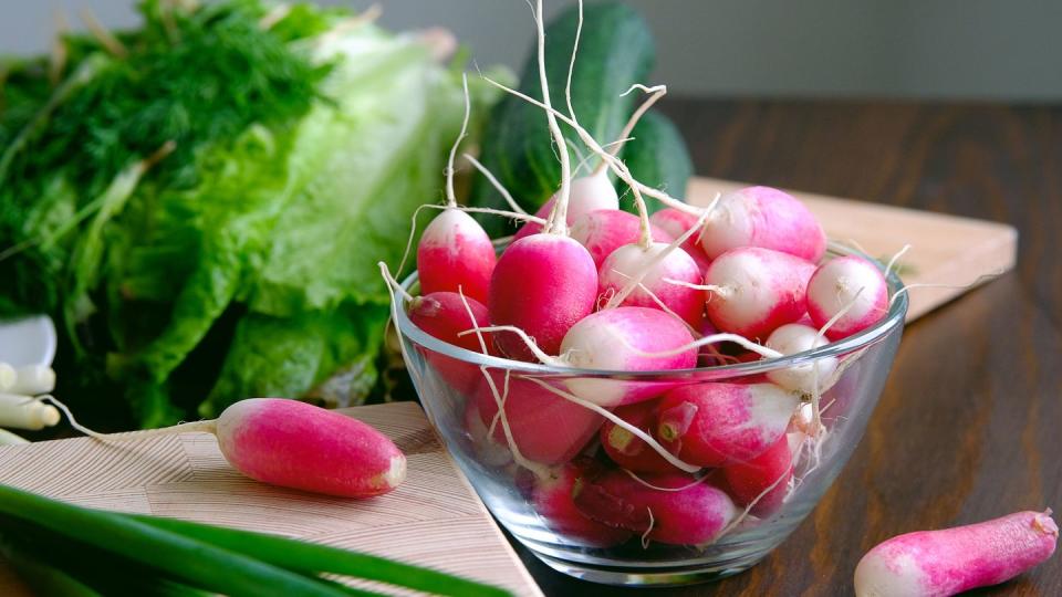 radish and green onions on a plate next to the green salad vegetables from the home garden natural organic agricultural products from the farm vegetarian, vegan and raw food food and diet harvesting home life