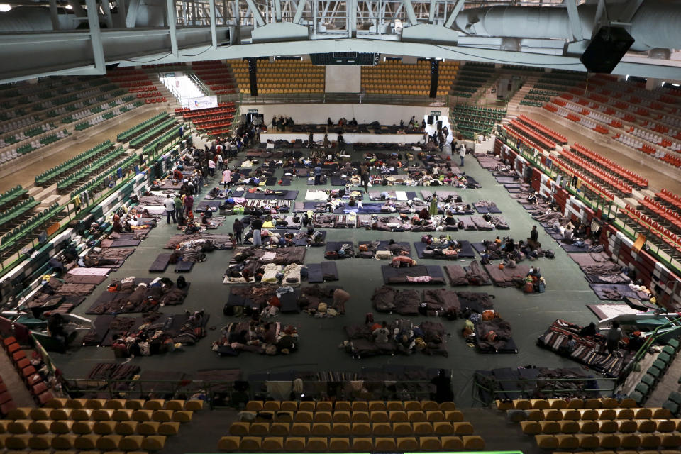 Migrantes de Centroamérica, África y el Caribe esperan su turno para solicitar asilo en Estados Unidos dentro de un albergue montado en el gimnasio Bachilleres de Ciudad Juárez, en México, el martes 19 de febrero de 2019. (AP Foto/Christian Torres)