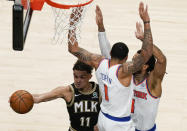 Atlanta Hawks' Trae Young (11) passes the ball against New York Knicks' Derrick Rose (4) and Obi Toppin (1) during the first half in Game 4 of an NBA basketball first-round playoff series Sunday, May 30, 2021, in Atlanta. (AP Photo/Brynn Anderson)