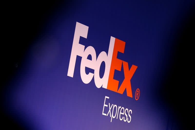 People stand near the FedEx Express logo during the presentation of the future extension of the FedEx hub in Roissy-en-France