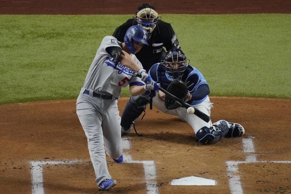 Los Angeles Dodgers' Corey Seager hits a RBI-single against the Tampa Bay Rays during the first inning in Game 5 of the baseball World Series Sunday, Oct. 25, 2020, in Arlington, Texas. (AP Photo/Sue Ogrocki)