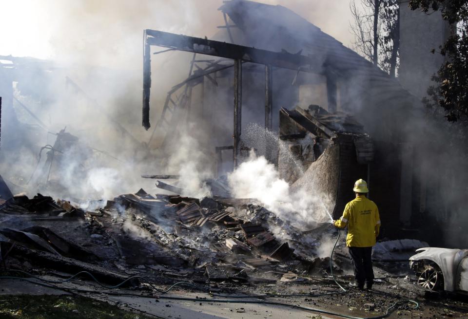 <p>A firefighter uses a garden hose to dose the smoldering ruins of a home destroyed by the Woolsey Fire in Agoura, California, on Nov. 9, 2018.<br>The Woolsey Fire has led to the evacuation order for 75,000 homes. Fires across California fueled by very dry conditions and warm strong Santa Ana winds have destroyed structures and caused fatalities.<br>(Photo from Mike Nelson, EPA) </p>