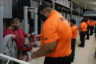 A security officer checks a fan arriving for an NCAA College Football Playoff national championship game between Alabama and Ohio State Monday, Jan. 11, 2021, in Miami Gardens, Fla. (AP Photo/Lynne Sladky)