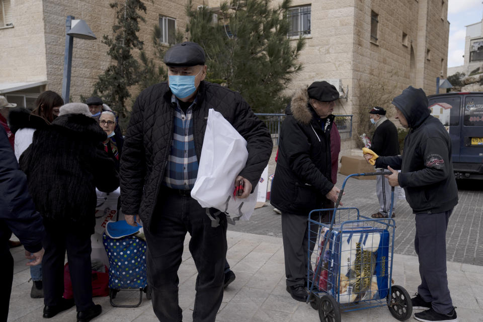 Several dozen impoverished elderly Israelis, many of them Holocaust survivors, gather for distribution of food aid and cold weather supplies by the Chasdei Naomi charity, ahead of International Holocaust Remembrance Day in Jerusalem, Wednesday, Jan. 26, 2022. Thursday marks the 77th anniversary of the liberation of the Nazi’s Auschwitz-Birkenau death camp in Poland. (AP Photo/Maya Alleruzzo)