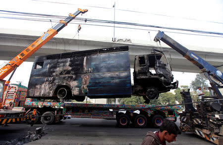 A police prison van, destroyed during clashes, is cleared from the road a day after the Tehrik-e-Labaik Pakistan Islamist political party called off nationwide protests in Islamabad, Pakistan November 28, 2017. REUTERS/Faisal Mahmood