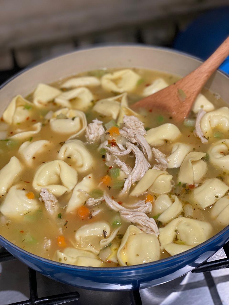 Chicken tortellini soup in a Dutch oven.