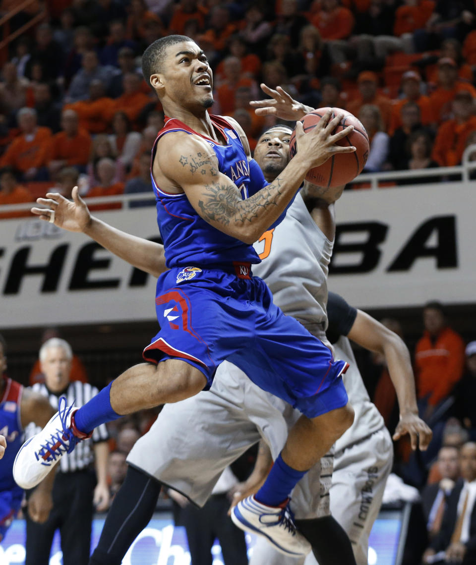 Kansas guard Frank Mason (0) goes up for a shot in front of Oklahoma State guard Marcus Smart (33) during the first half of an NCAA college basketball game in Stillwater, Okla., Saturday, March 1, 2014. (AP Photo/Sue Ogrocki)