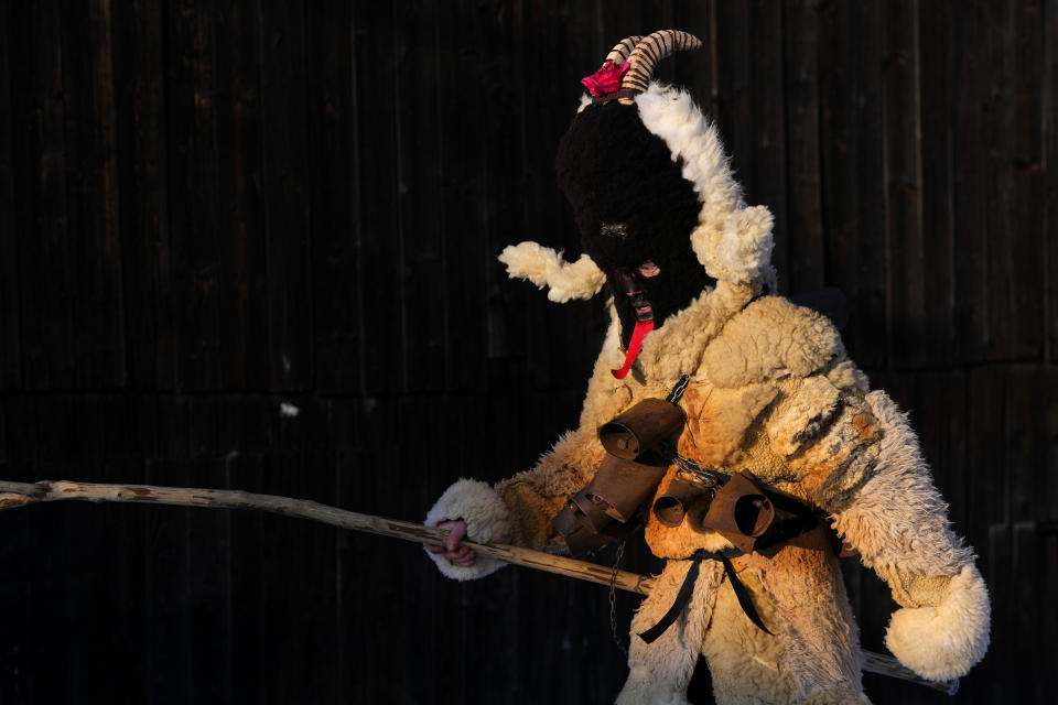 A reveler depicting a devil takes part in a traditional St. Nicholas procession in the village of Lidecko, Czech Republic, Monday, Dec. 4, 2023. This pre-Christmas tradition has survived for centuries in a few villages in the eastern part of the country. The whole group parades through village for the weekend, going from door to door. St. Nicholas presents the kids with sweets. The devils wearing home made masks of sheep skin and the white creatures representing death with scythes frighten them. (AP Photo/Petr David Josek)