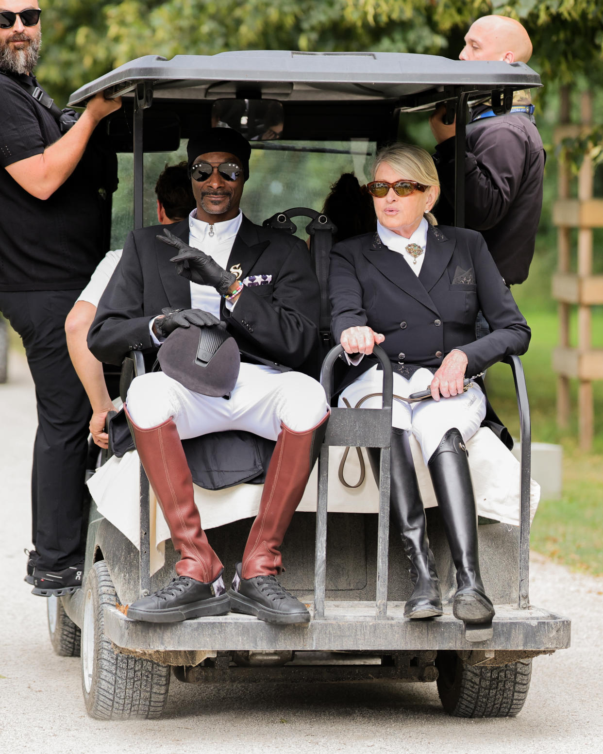 Snoop Dogg and Martha Stewart ride in a golf cart. 