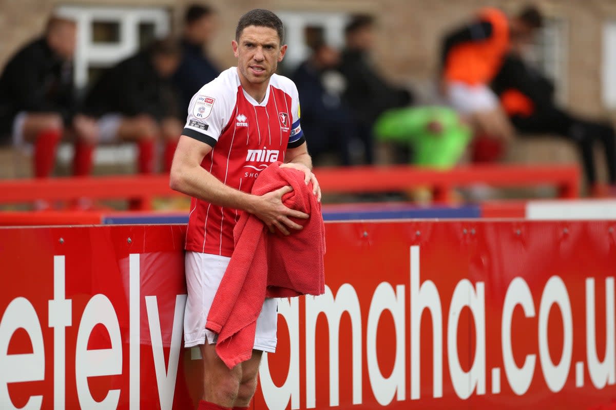 Ben Tozer dries the ball with a towel before taking a throw during his time with Cheltenham (Bradley Collyer/PA). (PA Archive)