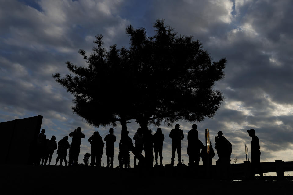 People watch as workers start to remove a section of the collapsed Francis Scott Key Bridge, Sunday, March 31, 2024, in Baltimore. (AP Photo/Julia Nikhinson)