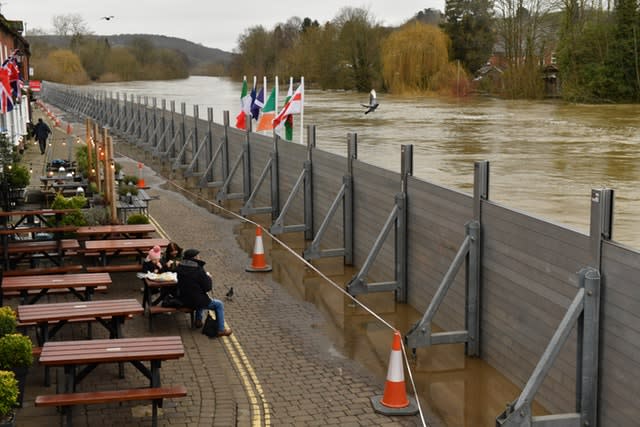 People eating in front of temporary flood defences in Bewdley, Worcestershire