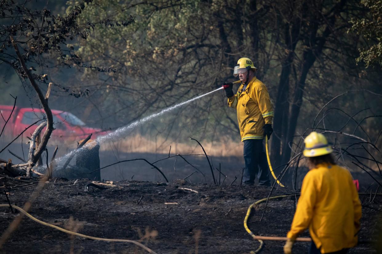 Fire crews mop up a brush fire on the east end of Alton Baker Park near the Knickerbocker Bike Bridge and Interstate 5 on Aug. 25 in Eugene.