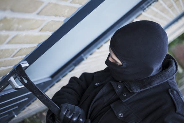 Burglar breaking in during the day in a residential area