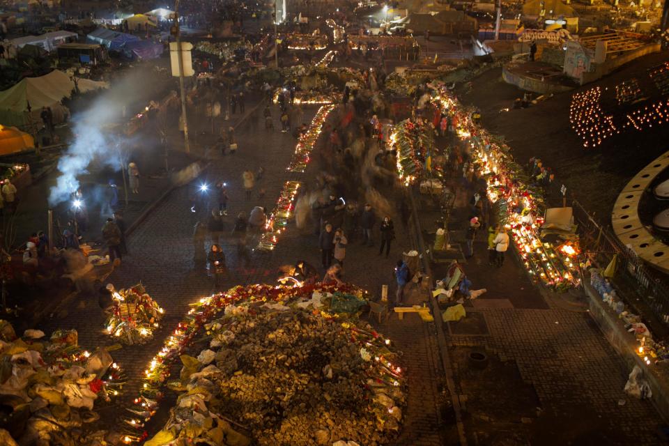 People light cantles and place flowers at a memorial for the people killed in clashes with the police at Kiev's Independence Square, the epicenter of the country's current unrest, Ukraine, Tuesday, Feb. 25, 2014. Parliament speaker says that a new government should be in place by Thursday, a delay reflecting intense ongoing consultations. Oleksandr Turchinov has previously said the new government could be formed on Tuesday. Turchinov was named Ukraine's interim leader after President Viktor Yanukovych fled the capital after signing a peace deal with opposition leaders to end violent clashes between police and protesters and Kiev. (AP Photo/Emilio Morenatti)