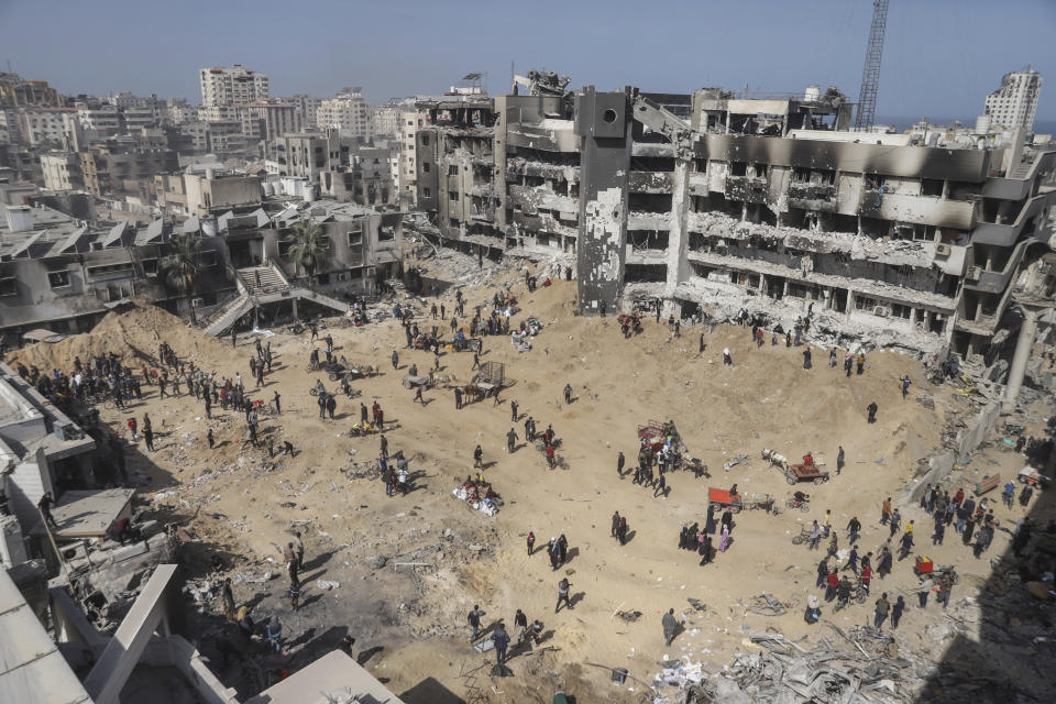 Palestinians walk through the destruction left by the Israeli air and ground offensive on the Gaza Strip near Shifa Hospital in Gaza City, Monday, April 1, 2024. (AP Photo/Mohammed Hajjar)