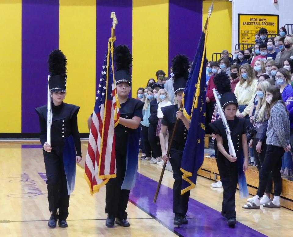 Members of the Pride of Paoli Marching Band conduct the retreat of the colors during the Paoli Junior-Senior High School Veterans Day Program.