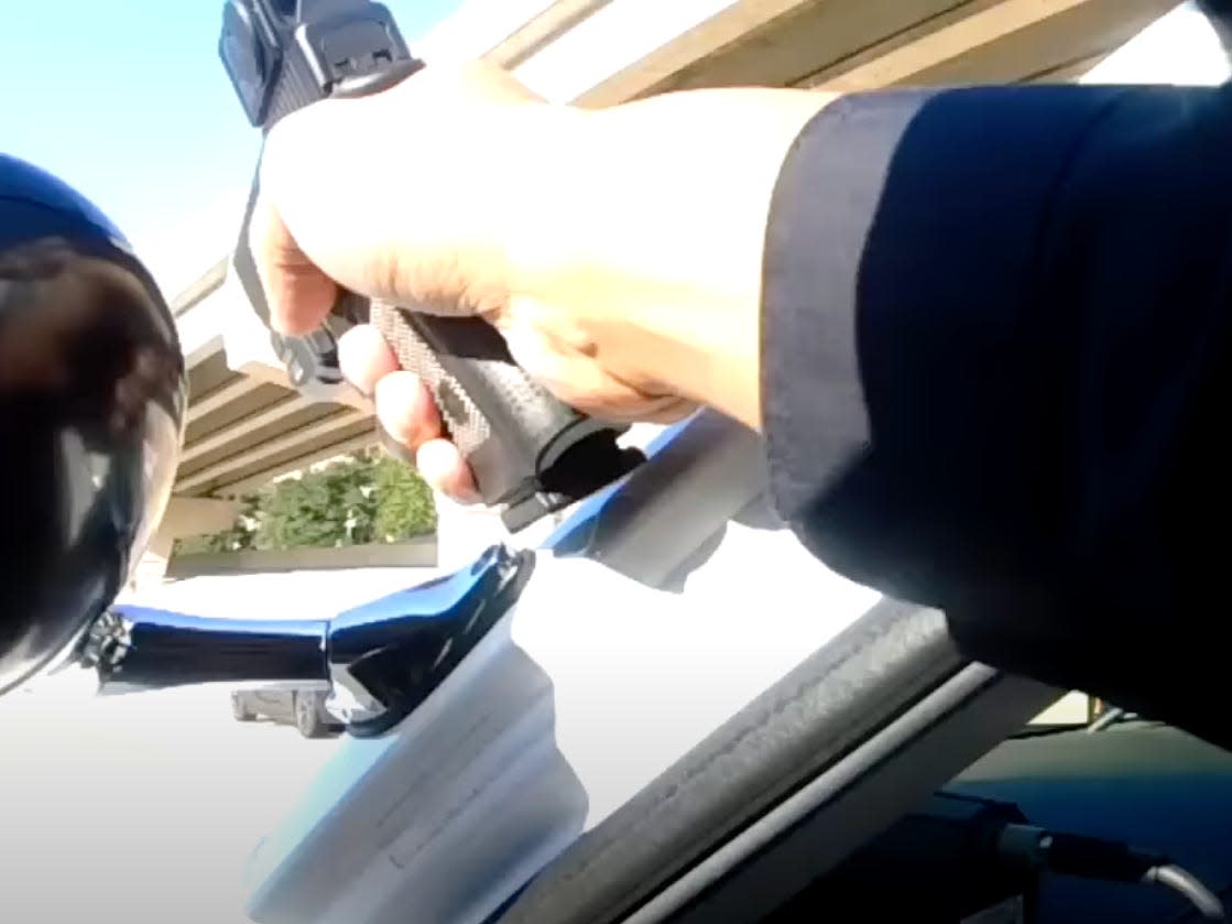 Body cam footage shows an officer pointing a gun.