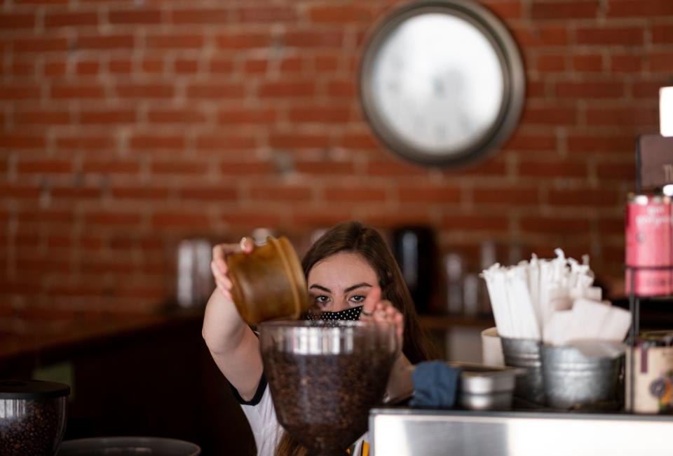 A worker of the Aspen Cafe wears a mask as she makes coffee on May 5, 2020 in Stillwater, Oklahoma. - In the face of intimidation against employees and the threat of an armed attack by local residents wielding their individual liberties, the mayor of Stillwater had to give in: he gave up imposing the wearing of masks on customers in shops. This demand was included in a 21-page document that was supposed to accompany the gradual reopening of restaurants and shops from 1 May, as authorized by the state of Oklahoma. "About three and a half hours after the law came into effect" of the text, "we started receiving calls from stores claiming that employees were being threatened and insulted, and threatened with physical violence," said Norman McNickle, the city's director of services. (Photo by Johannes EISELE / AFP) (Photo by JOHANNES EISELE/AFP via Getty Images)