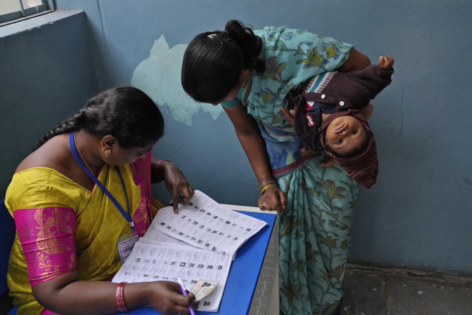 FILE - A woman checks for her name before casting her vote at a polling station during the Telangana state assembly elections in Hyderabad, India, Thursday, Nov. 30, 2023. (AP Photo/Mahesh Kumar A., File)