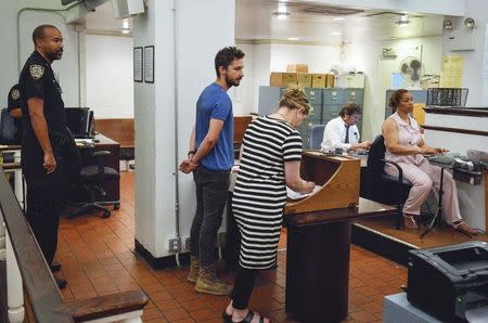 Shia LaBeouf (center), is arraigned in Midtown Community Court in New York June 27, 2014. REUTERS/Anthony DelMundo/Pool