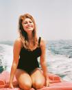 <p>Sophia Loren smiles from the stern of a motorboat. The Italian actress looks sun-kissed in a black one-piece bathing suit. </p>