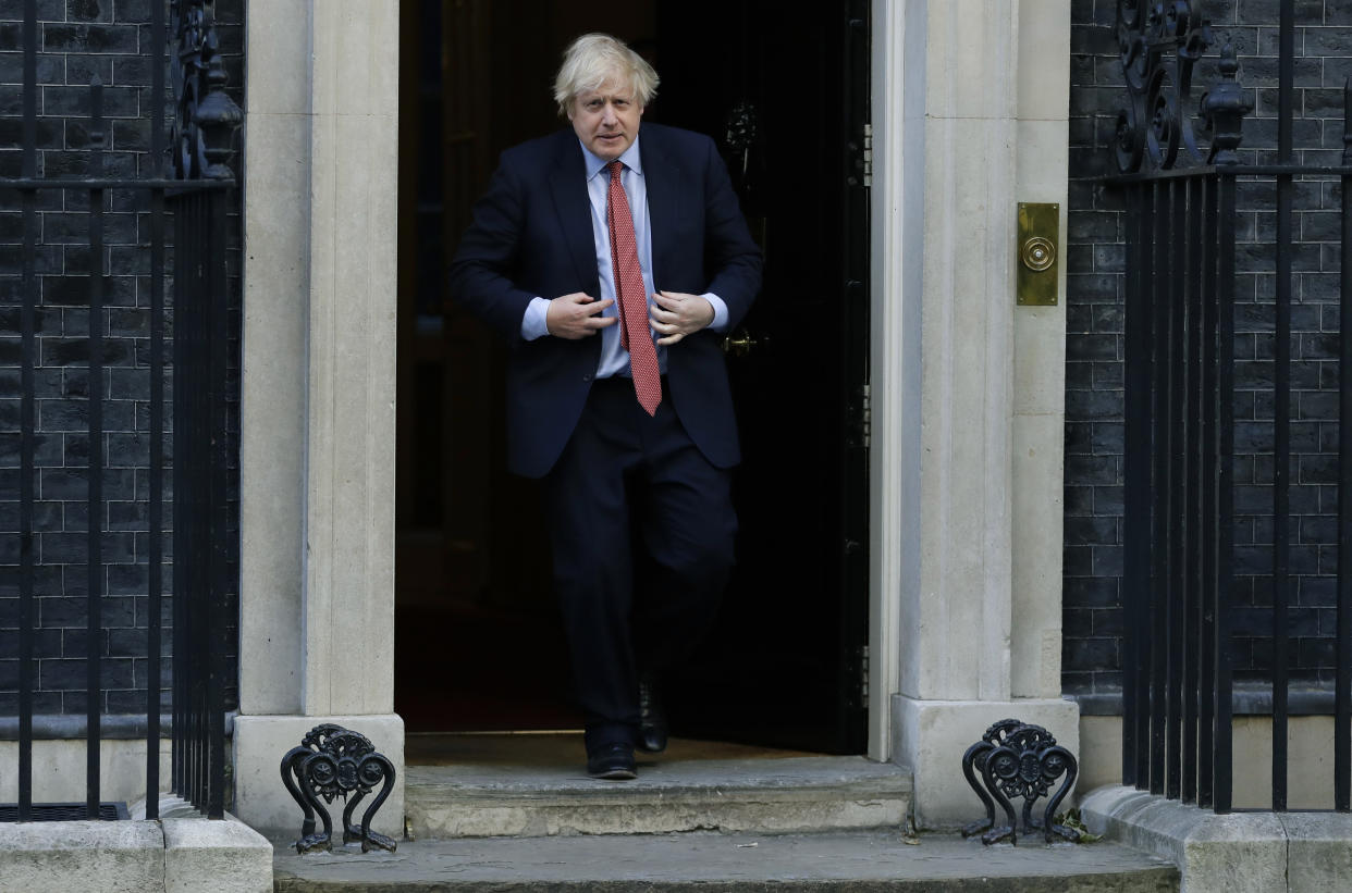 Britain's Prime Minister Boris Johnson comes out to applaud on the doorstep of 10 Downing Street, during the weekly "Clap for our Carers", in London, Thursday, May 28, 2020. The COVID-19 coronavirus pandemic has prompted a public display of appreciation for care workers. The applause takes place across Britain every Thursday at 8pm local time to show appreciation for healthcare workers, emergency services, armed services, delivery drivers, shop workers, teachers, waste collectors, manufacturers, postal workers, cleaners, vets, engineers and all those helping people with coronavirus and keeping the country functioning while most people stay at home in the lockdown. (AP Photo/Kirsty Wigglesworth)