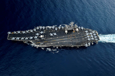 FILE PHOTO - Chief Petty Officers stand in formation on the flight deck of the U.S. Navy aircraft carrier USS Theodore Roosevelt for a photo honoring the 125th birthday of the Navy Chief Petty Officer rate, in the Strait of Malacca April 1, 2018. U.S. Navy/Mass Communication Specialist 3rd Class Anthony J. Rivera/Handout via REUTERS/File Photo