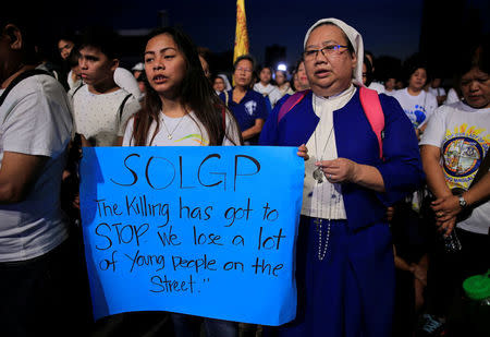 A Catholic nun and student display a placard as they participate in a procession against plans to reimpose death penalty and intensify drug war during "Walk for Life" in Luneta park, Metro Manila, Philippines February 24, 2018. REUTERS/Romeo Ranoco