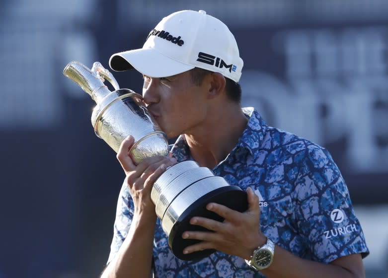United States' Collin Morikawa kisses the claret jug trophy as he poses for photographers on the 18th green after winning the British Open Golf Championship at Royal St George's golf course Sandwich, England, Sunday, July 18, 2021. (AP Photo/Peter Morrison)