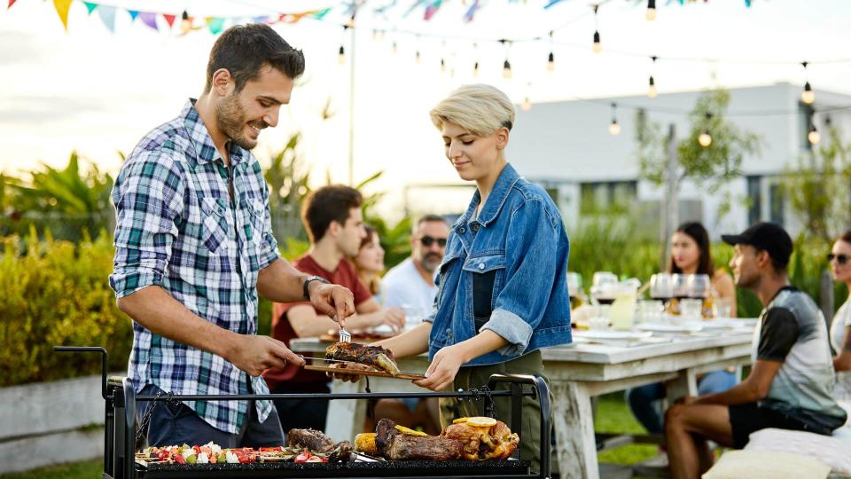 Happy man serving meat while woman holding board.