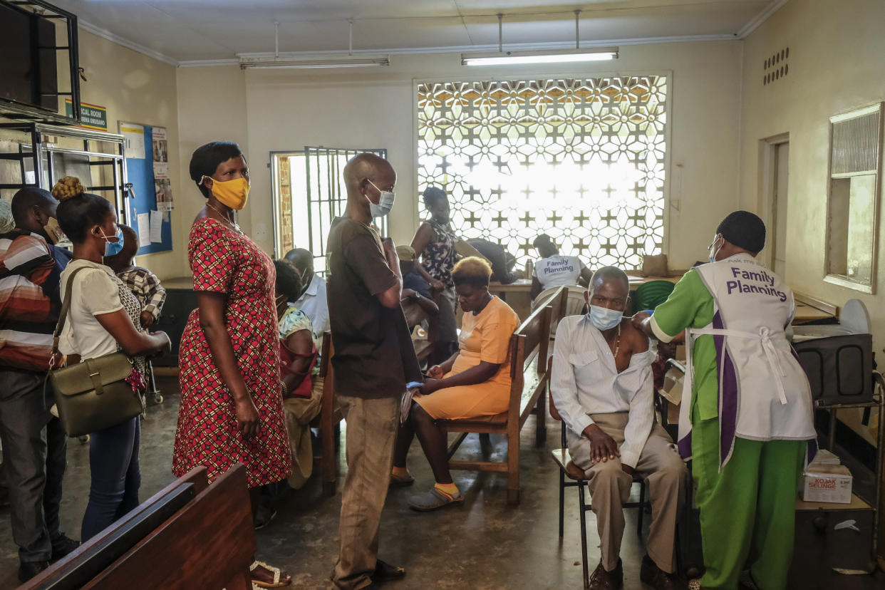 FILE - Ugandans receive Pfizer coronavirus vaccinations at the Kiswa Health Centre III in the Bugolobi neighborhood of Kampala, Uganda Tuesday, Feb. 8, 2022. In the latest Senate package targeted at stopping the coronavirus, U.S. lawmakers dropped nearly all funding for curbing the virus beyond its borders, in a move many health experts describe as dangerously short-sighted. They warn the suspension of COVID aid for poorer countries could ultimately spur the kind of unchecked transmission needed for the next worrisome variant to emerge. (AP Photo/Hajarah Nalwadda, File)