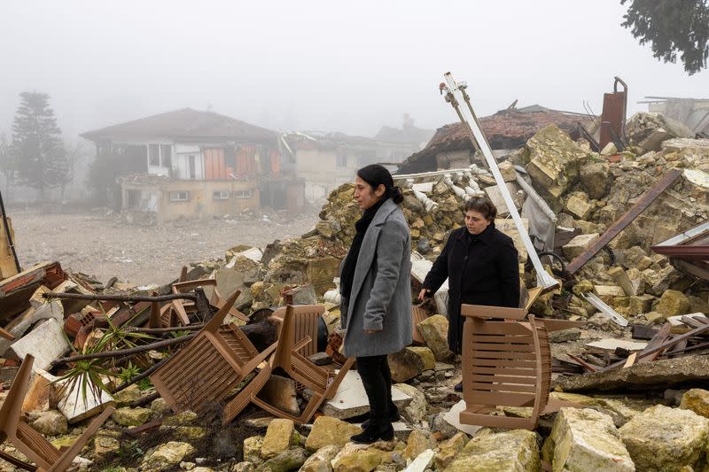 Worshippers walk on the ruins before they attend a mass for those of their community killed by last year's earthquake at Greek Orthodox Church in Hatay