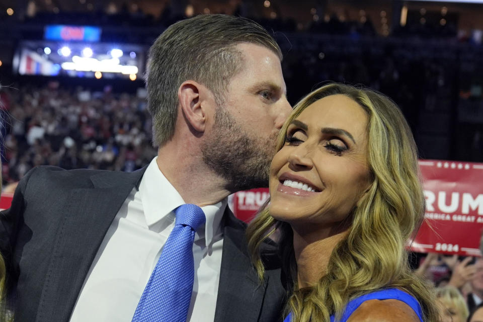 Eric Trump kisses his wife Lara Trump during the roll call of states during the first day of the Republican National Convention, Monday, July 15, 2024, in Milwaukee. (AP Photo/Evan Vucci)