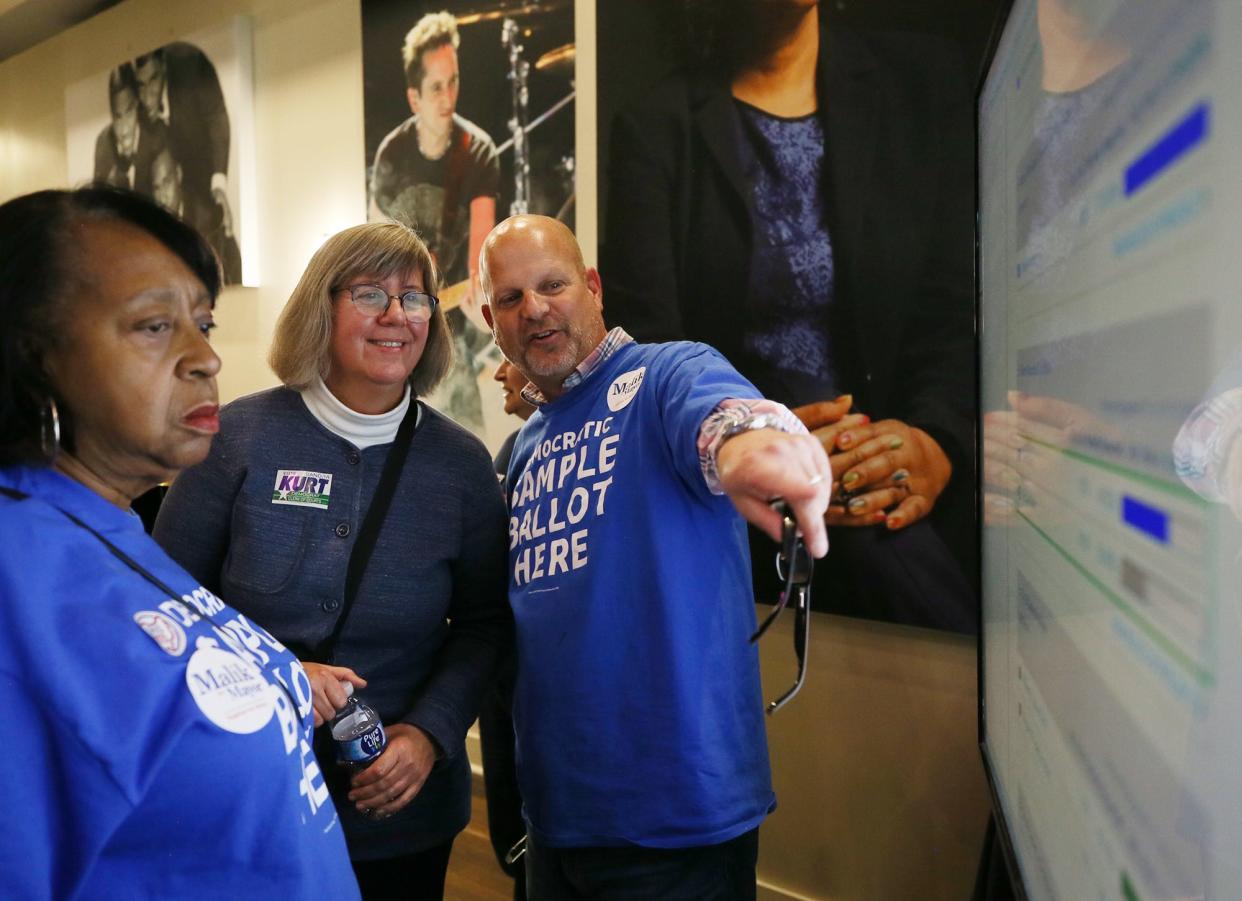 Edna Borders, Sandra Kurt and Mark Derrig look at election returns during the Summit County Democratic Party's election night party and the Akron Civic Theatre. Kurt, the current Summit County clerk, was elected the Akron clerk in Tuesday's election.