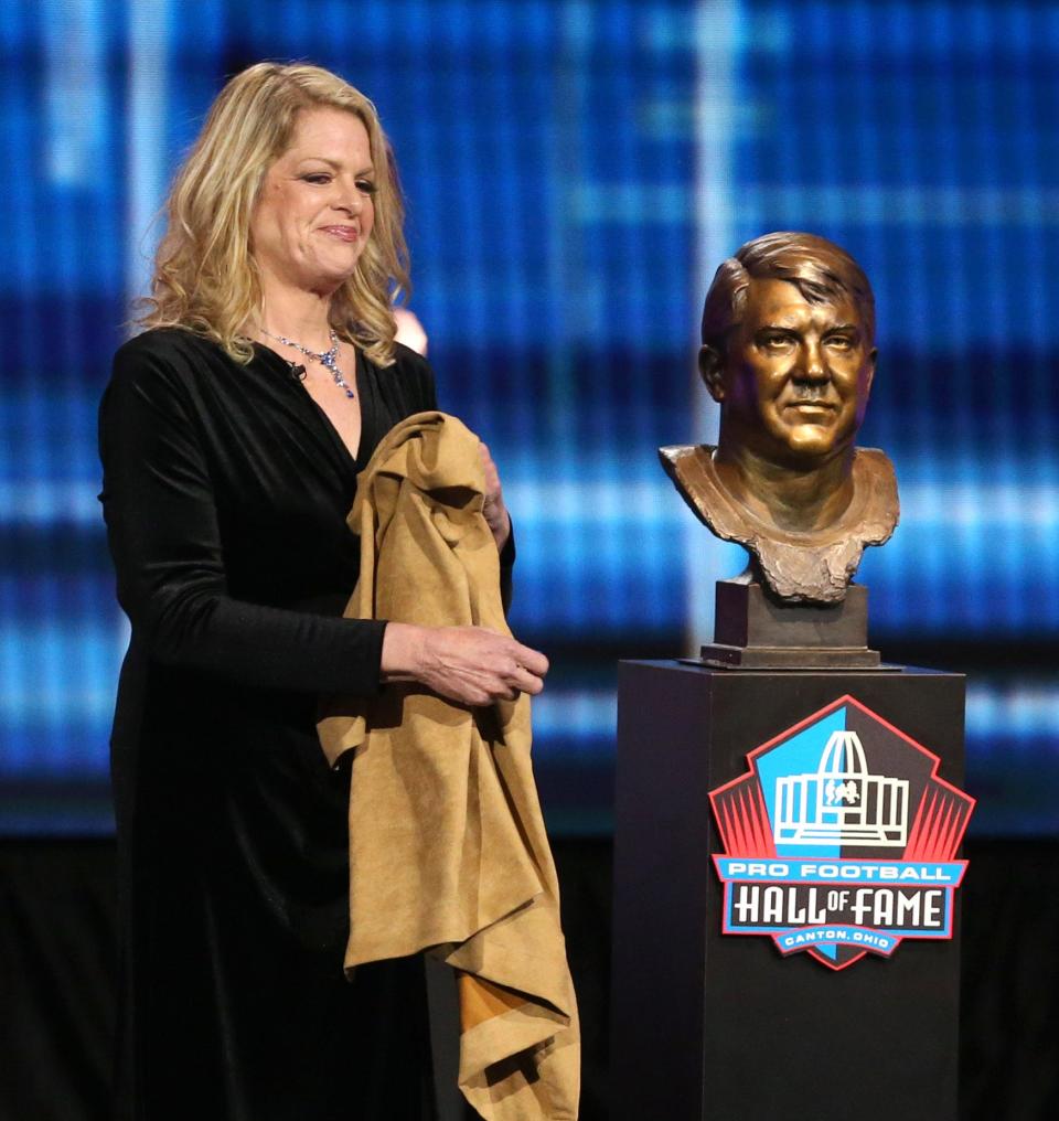 Carolyn Karras smiles beside the bust of her father Alex Karras as one of the newest members of the Pro Football Hall of Fame at Umstattd Hall in Canton on Wednesday, April 28, 2021. The event posthumously recognized his contributions to the game.