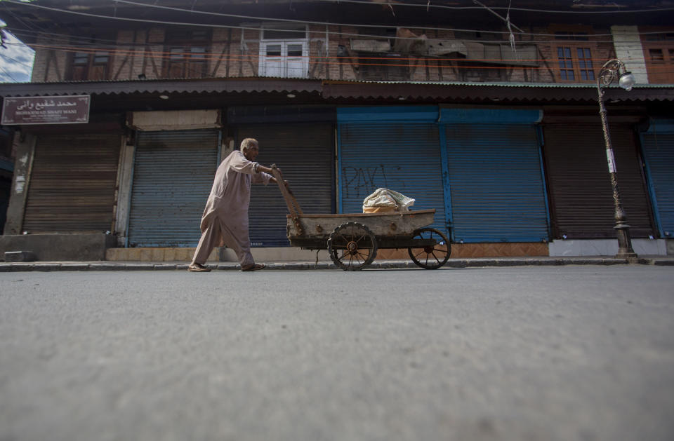 A Kashmiri man pushes a handcart through a closed market in Srinagar, Indian controlled Kashmir, Sunday, Sept. 5, 2021. Authorities Sunday eased some restrictions that had been imposed after the death of top resistance leader Syed Ali Geelani. However, most shops and businesses stayed closed as government forces patrolled roads and streets in the city. (AP Photo/Mukhtar Khan)