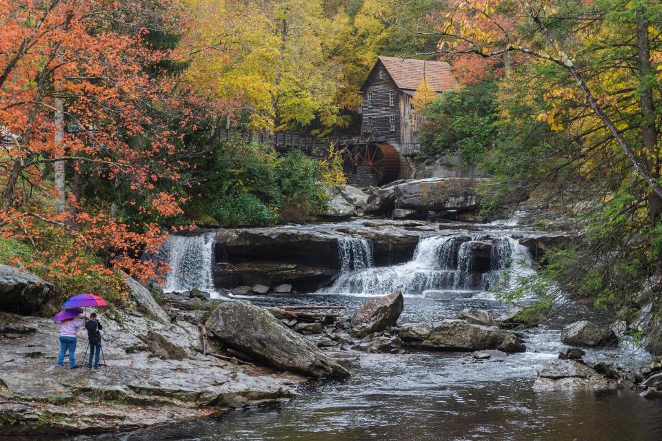 Visitors snap photos on a rainy day amidst fall colors surrounding the Glade Creek Grist Mill inside Babcock State Park near Clifftop, W.Va., Oct. 27, 2018. This is one of the most photographed spots in West Virginia, according to the state's Department of Tourism.