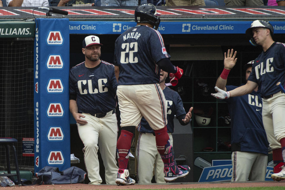 Cleveland Guardians' Josh Naylor (22) is congratulated by manager Stephen Vogt, left and Will Brennan, right, after hitting a two-run home run off Kansas City Royals starting pitcher Seth Lugo during the fourth inning of a baseball game in Cleveland, Tuesday, June 4, 2024. (AP Photo/Phil Long)