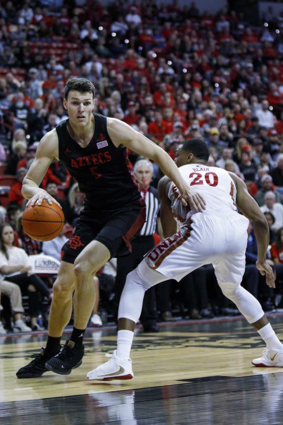 San Diego State's Yanni Wetzell (5) drives to the rim against UNLV's Nick Blair (20) during the second half of an NCAA college basketball game on Sunday, Jan. 26, 2020, in Las Vegas. (AP Photo/Joe Buglewicz)