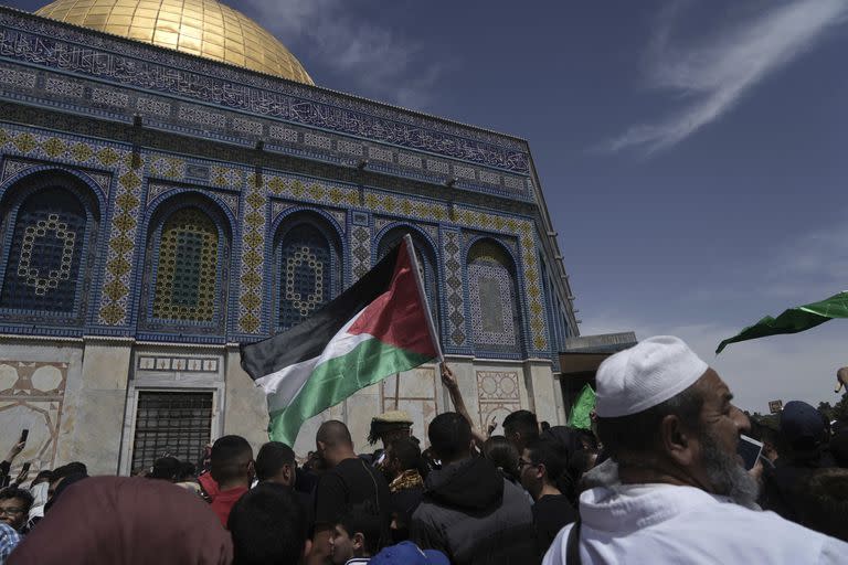 Un fiel ondea una bandera palestina tras la oración del viernes en el mes del ramadán, que es sagrado para los musulmanes, horas después de enfrentamientos entre la policía israelí y los manifestantes en el recinto de la mezquita de Al Aqsa, en la Ciudad Vieja de Jerusalén, el 22 de abril de 2022.