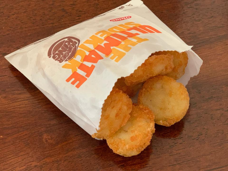 Burger King hash browns in original bag on a wooden table